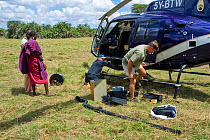 Simon Werry and Mike Watson derigging Cineflex camera from helicopter watched by locals. Amboseli, Kenya. December 2007 Taken on location for BBC tv series 'Life'