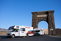 Cars under Roosevelt Arch entrance to Yellowstone National Park, Montana, USA, October 2008