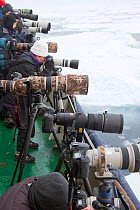 Row of cameras on deck of ship ready to photograph Polar bear, Svalbard, Norway, September 2009
