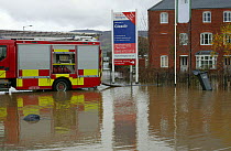 Fire engine working to drain flooding of newly built housing in Glasdir estate, with houses for sale, Ruthin, Vale of Clwyd, Denbighshire, Wales, UK.  This is an area at risk of flooding and therefore...