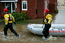 Members of north wales fire service with boat to rescue people affected by flooding of newly built housing in the Glasdir estate, Ruthin, Vale of Clwyd, Denbighshire, Wales, UK.  This is an area at ri...