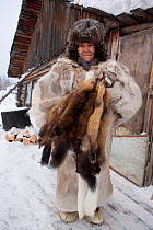 Yalena, an elderly Selkup woman holds sable skins caught by her husband at their winter camp in the forest. Krasnoselkup, Yamal, Western Siberia, Russia 2012