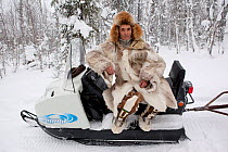 Kosta, a Selkup hunter, rests on his snowmobile while out checking his sable traps in the forest. Krasnoselkup, Yamal, Western Siberia, Russia 2012