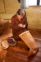 Yalena, an elderly Selkup woman, sewing a pair of traditional reindeer skin boots, Krasnoselkup, Yamal, Western Siberia, Russia 2012