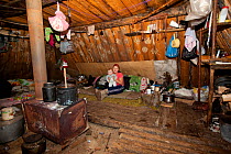 Lena Kuboleva, a young Selkup woman, with her daughter Violetta, inside a 'Poymot', (traditional Selkup turf winter hut), at a winter hunting camp in the forest near Ratta, Krasnoselkup, Yamal, Wester...