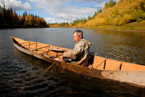 On an autumn day, Gennadiy Kubolev, a Selkup man, checks a fishing net from his 'Anty' (traditional dugout boat) on the River Shirta,  Krasnoselkup, Yamal, Western Siberia, Russia