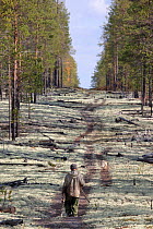 Gennadiy Kubolev, a Selkup man, sets off along a seismic line cut in the forest to hunt with his dog,  Krasnoselkup, Yamal, Western Siberia, Russia
