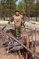 Gennadiy Kubolev, a Selkup hunter, holds two Capercaille he has caught in a 'Chang' (traditional deadfall trap), in the forest, Krasnoselkup, Yamal, Western Siberia, Russia