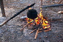 A kettle hangs over an open fire to boil at a Selkup camp in the forest, Krasnoselkup, Yamal, Western Siberia, Russia