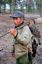 Gennadiy Kubolev, a Selkup man, returns from hunting in the forest carrying his catch of two Capercailles, Krasnoselkup, Yamal, Western Siberia, Russia