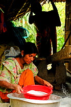 A woman sifting rice, the Sundarbans National Park, UNESCO World Heritage Site. June 2012.