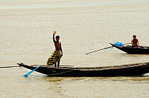 Man waving from a boat, Sundarbans National Park, the largest mangrove swamp in the world. Bangladesh. UNESCO World Heritage Site. June 2012.