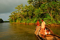 Men on a traditional wooden boat, Sundarbans National Park, the largest mangrove swamp in the world, Bangladesh, UNESCO World Heritage Site. June 2012.