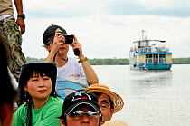Japanese tourists taking photographs in Sundarbans National Park, the largest mangrove swamp in the world. Bangladesh UNESCO World Heritage Site. June 2012.