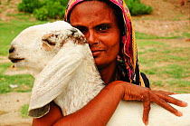 Woman holding her goat near the River Ganges. Bangladesh. June 2012.