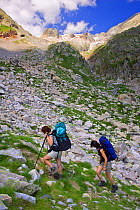 Two women hiking in Remune valley, Posets-Maladeta Natural Park, Pyrenees, Huesca, Aragon, Spain. Model released.