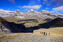 Mountain walkers at Cilindro de Marbora, with Monte Perdido (3355 m)  peak in Ordesa valley, Ordesa and Monte Perdido National Park, Pyrenees, Aragon, Spain