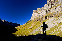 Lone hiker silhouetted in the shadows of Ordesa valley, Ordesa and Monte Perdido National Park, Pyrenees, Aragon, Spain