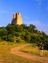 Hiker approaching Mur castle, Pyrenees, Pallars Jussa, Catalonia, Spain, Model released
