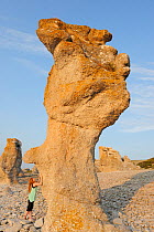 Mimmi Widstrand next to rock formation on beach, Gotland, Sweden's largest island, August 2010. Model released