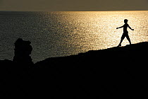 Mimmi Widstrand near rauk / stack on beach at sunset, Faro, Gotland, Sweden's largest island August 2010 Model released