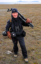 Photogrpaher Staffan Widstrand, carrying photographic equipment, Svalbard, Norway July 2011