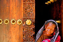 Elderly lady in carved wooden doorway, Stone Town, Zanzibar, Tanzania