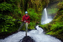 Photographer Floris van Breugel asbeiling down a waterfall in Columbia River Gorge, Oregon, USA. May 2011. Model released