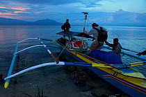 Boarding pumpboat used to travel from Foli to Labilabi along the Halmahera coast, Maluku Islands, Indonesia 2008