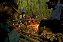 Villagers from Syoubri Village in the Arfak Mountains around a camp fire at  camp site at 2000 m, Indonesian New Guinea 2009