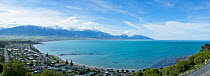 Wide angle view of coastline, town and mountains. Kaikoura, New Zealand, October.