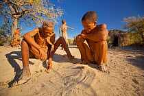 A Zu/'hoasi Sangoma (Zulu healer) and a young Bushman interpret signs having asked for guidance from ancestral spirits before setting out to hunt in the Kalahari, Botswana. April 2012.