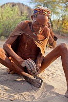 A Zu/'hoasi Bushman Sangoma (Zulu healer) prepares to throw special wooden sticks into the sand and ask for guidance from ancestral spirits before setting out to hunt in the Kalahari, Botswana. April...
