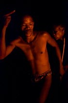 Zu/'hoasi Bushmen dance around a fire as part of a traditional Trance Dance where a Sangoma (Zulu healer) will perform traditional healing while in an altered state of consciousness. Kalahari, Botswan...