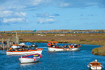 Morston Quay with boats containing tourists leaving to view the seals at Blakeney Point, Norfolk, England, September 2012