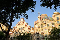 Two modernist buildings : left, Casa Amatller by architect Puig i Cadafalch and Casa Batll on the right by architect Antoni Gaudi, with tree in the foreground, Eixample District, Barcelona City, Spain...