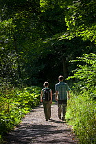 Couple walking in Water-cum-Jolly Dale, Peak District National Park, Derbyshire, UK. August 2012