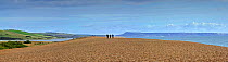 Fleet Lagoon at Abbotsbury and tourists walking on Chesil Beach tombolo, one of three major shingle structures in Britain along the Jurassic Coast, World Heritage Site, Dorset, UK, November 2012. No r...