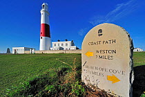 Portland Bill Lighthouse and stone signpost for the coast path on the Isle of Portland along the World Heritage Jurassic Coast, Dorset, UK, November 2012