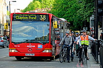 Bus and commuter cyclists waiting at traffic lights, Angel, London Borough of Islington, UK