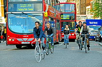 Commuter cyclists and buses in rush hour traffic, Angel, London Borough of Islington, UK, May 2009