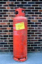 Envirocrime label stuck onto a cylinder with inflammable contents dumped in street, London Borough of Islington, UK