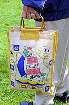 Man holding reusable cotton bag, London UK