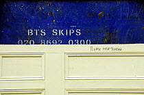 Old door in front of skip offered for recycling with a note saying Please Help Yourself, Highbury, London Borough of Islington, UK