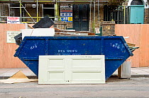 Old door in front of skip offered for recycling with a note saying Please Help Yourself, Highbury, London Borough of Islington, UK