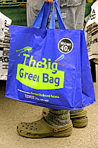 The big green bag, Tesco reusable shopping bag held by man, Islington Farmers Market, London, UK