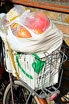Shopping in reusable cotton bag in wire backet on bicycle, London, UK