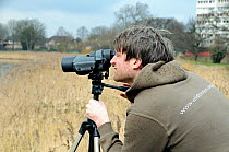 David Mooney, London Wildlife Trust warden birdwatching at Stoke Newington East Reservoir, London Borough of Hackney, UK, March