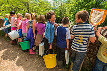 School children with equipment to do kick sampling, invertebrate identification, and release salmon fry in the River Haddeo, Bury, Exmoor National Park, Somerset, UK. May 2012. Editorial use only
