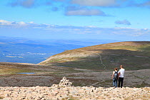 Man and woman walking in mountains, Cairngorms National Park, Scotland, Uk